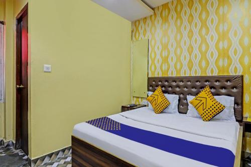 a bedroom with a bed with yellow and blue at SPOT ON Gayatri Lodge Near Snow World in Secunderabad