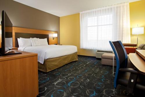 Habitación de hotel con cama y TV en TownePlace Suites by Marriott Carlsbad en Carlsbad