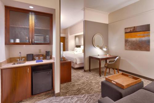 a hotel room with a bed and a living room at SpringHill Suites Thatcher in Thatcher