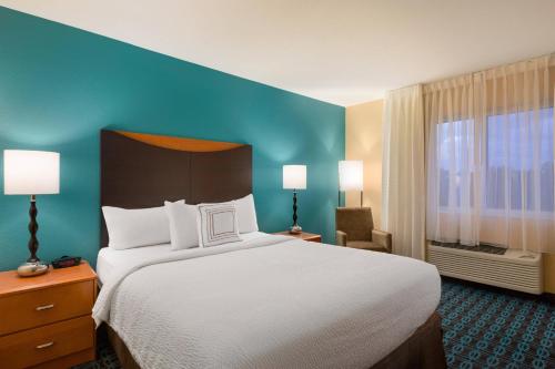 1 dormitorio con 1 cama grande y pared azul en Fairfield by Marriott Inn & Suites Houston North/Cypress Station, en Houston