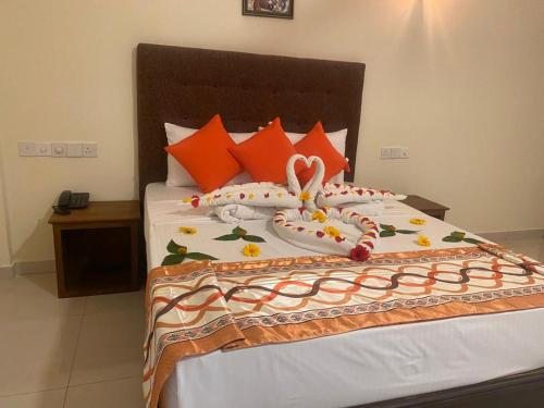a bed with orange and white pillows at Hotel NorthWay in Vavuniya