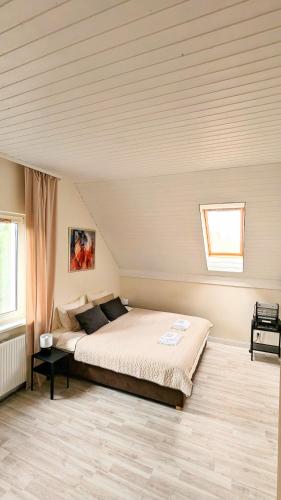 a bedroom with a large bed in a room at Vila Vynuogyne in Paberžė
