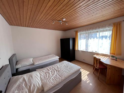 a bedroom with a bed and a desk and a window at FeWo Michistrasse in Forchheim