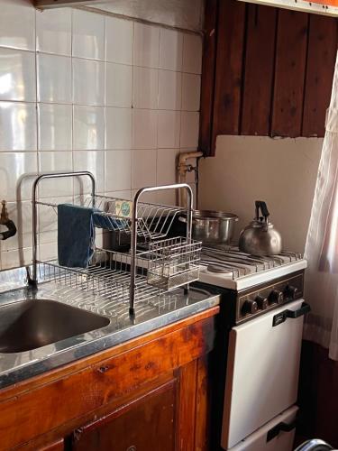 una cucina con lavandino e ripiano per piatti; di hermosa cabaña a San Carlos de Bariloche