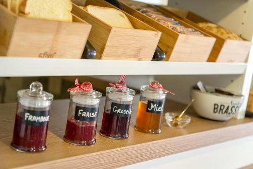 a shelf with four jars of jam and bread at Les Pins Blancs en Provence in Le Muy