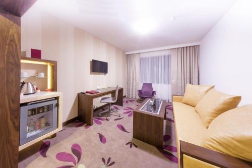 アルバ・ユリアにあるHotel Transilvaniaのベッドとデスクが備わるホテルルームです。