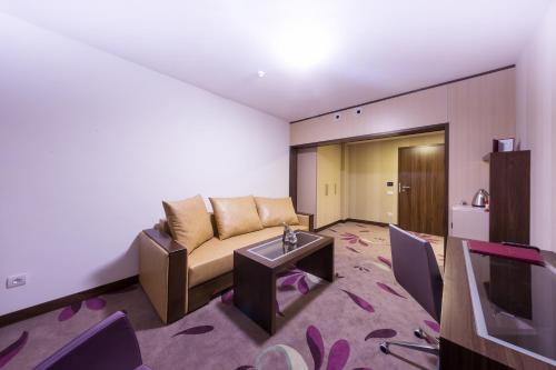 a living room with a couch and a tv at Hotel Transilvania in Alba Iulia