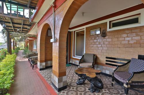 a patio with chairs and a table on a building at De Rock Jungle Living Resort in Coonoor