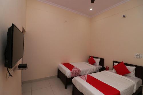 een kamer met 2 bedden en een flatscreen-tv bij OYO Flagship 27941 Sangam Darshan in Naini