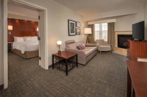 Habitación de hotel con cama y sala de estar. en Residence Inn Dulles Airport At Dulles 28 Centre en Sterling