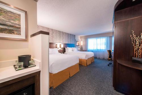 a hotel room with two beds and a television at Courtyard by Marriott Columbus in Columbus