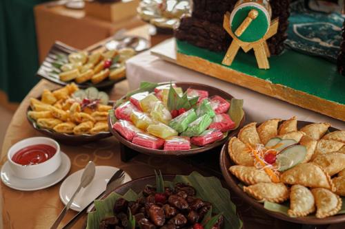 a table topped with bowls of different types of food at HARRIS Hotel Samarinda in Samarinda