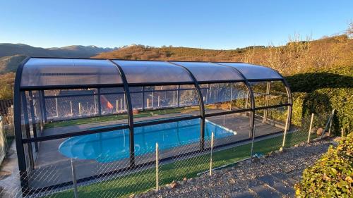 a glass house with a swimming pool inside at Atardecer en Gredos 2 in San Bartolomé de Tormes