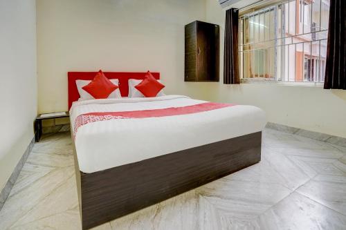 a bedroom with a large bed with red pillows at Hotel O Avisi Residency in Bhubaneshwar
