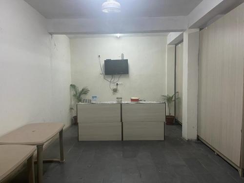 a room with a desk and a tv on a wall at Abuzz OxfordCaps, Genome Valley Hyderabad in Hyderabad