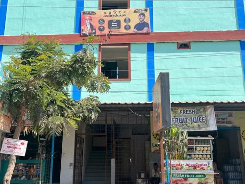 un bâtiment bleu avec un panneau devant lui dans l'établissement Abuzz OxfordCaps, Genome Valley Hyderabad, à Hyderabad