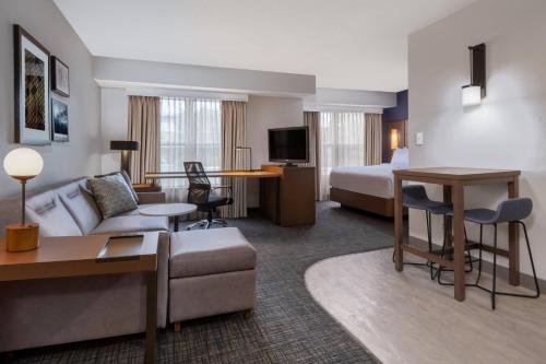um quarto de hotel com um sofá e uma cama em Residence Inn Austin South em Austin