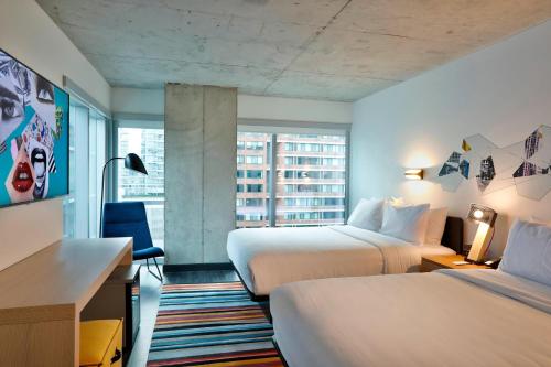 a hotel room with two beds and a desk at Aloft Chicago Mag Mile in Chicago