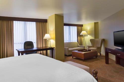 a hotel room with a bed and a television at Sheraton Houston Brookhollow in Houston