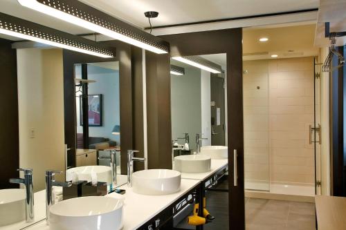 Baño con 4 lavabos y una fila de espejos en Aloft Chicago Mag Mile, en Chicago