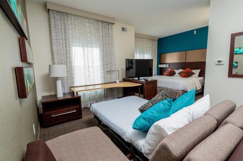 um quarto de hotel com duas camas e um sofá em Residence Inn by Marriott Cleveland Avon at The Emerald Event Center em Avon