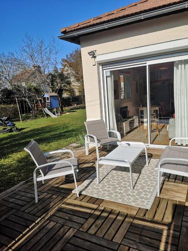 un groupe de chaises assises sur une terrasse dans l'établissement Maisonnette de Charme à 10min de Fontainebleau, à Héricy