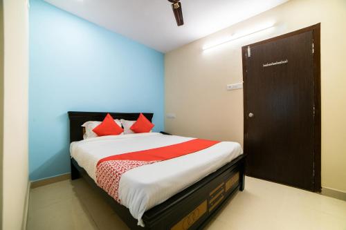 a bedroom with a bed with red pillows at Hotel O White Ridge in Hyderabad