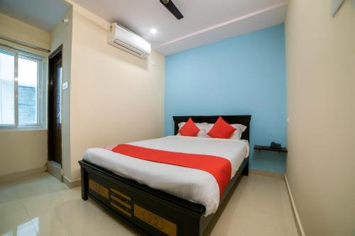 a bedroom with a large bed with red pillows at Hotel O White Ridge in Hyderabad
