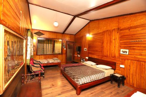 a bedroom with wooden walls and a bed and a chair at De Rock Jungle Living Resort in Coonoor