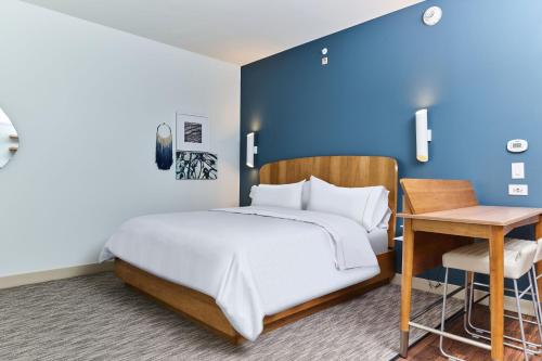 Element Chattanooga East Marriott في تشاتانوغا: غرفة نوم بسرير مع جدار ازرق