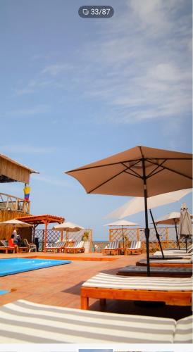 a patio with an umbrella and a pool at La Cabaña Glamping Geronimo in Playa Blanca
