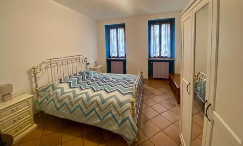 sypialnia z łóżkiem i 2 oknami w obiekcie Appartamento in cascina -la cascinetta di Ali- w mieście Roatto