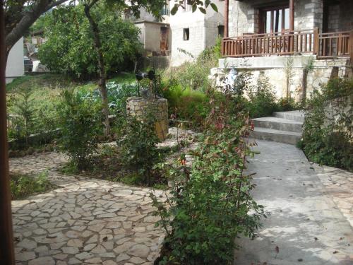 a garden with a stone walkway in front of a house at Theasis suites-Ορεινή Φιλοξενία in Kato Trikala Korinthias