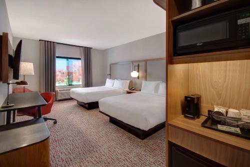 a hotel room with two beds and a flat screen tv at Fairfield Inn & Suites Lancaster Palmdale in Lancaster