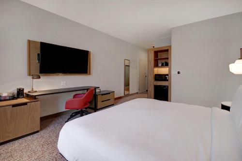 a hotel room with a bed and a desk and a television at Fairfield Inn & Suites Lancaster Palmdale in Lancaster