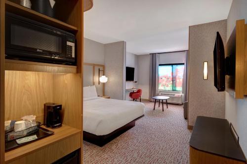 a hotel room with a bed and a television at Fairfield Inn & Suites Lancaster Palmdale in Lancaster