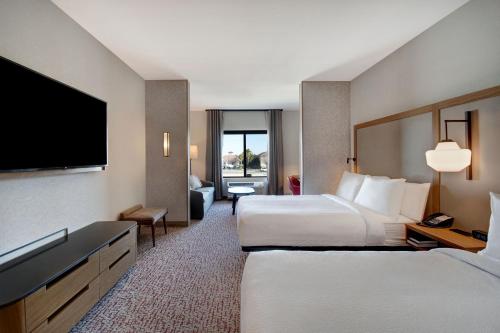 a hotel room with two beds and a flat screen tv at Fairfield Inn & Suites Lancaster Palmdale in Lancaster
