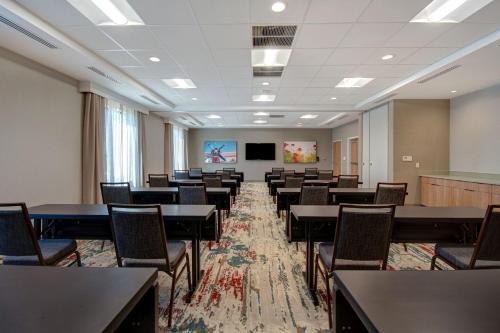 a large room with tables and chairs and a screen at Fairfield Inn & Suites Lancaster Palmdale in Lancaster