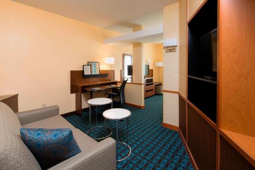 a hotel room with a couch and a desk with a computer at Fairfield Inn & Suites by Marriott Newark Liberty International Airport in Newark