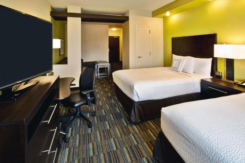 a hotel room with two beds and a flat screen tv at Fairfield Inn and Suites by Marriott Austin Northwest/Research Blvd in Austin