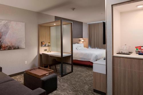 カリスペルにあるSpringHill Suites by Marriott Kalispellのベッドとバスルーム付きのホテルルームです。