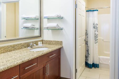a bathroom with a sink and a mirror and a shower at Residence Inn Sioux Falls in Sioux Falls