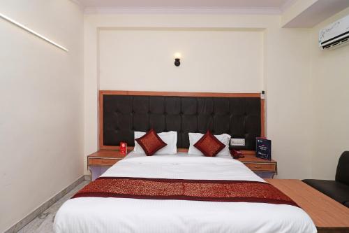 1 dormitorio con 1 cama grande y cabecero negro en OYO Hotel Silver Shine Near Gurudwara Shri Bangla Sahib, en Nueva Delhi