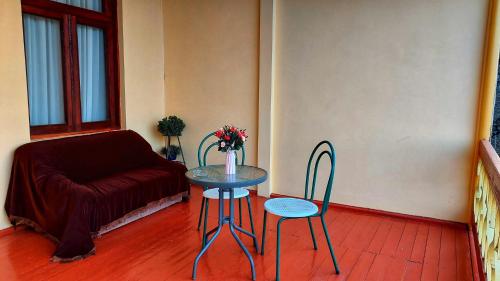 a table and chairs in a living room with a couch at Guesthouse ''Door'' in Sighnaghi in Sighnaghi