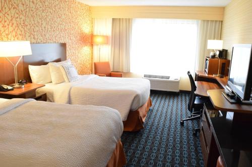a hotel room with two beds and a flat screen tv at Fairfield Inn by Marriot Binghamton in Binghamton