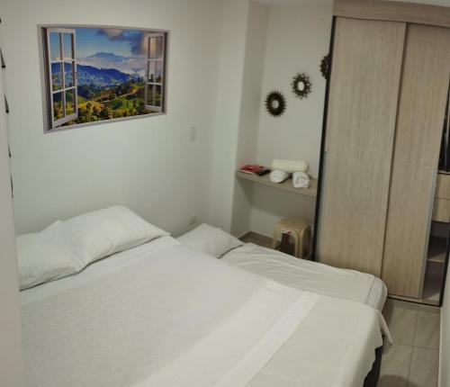 1 dormitorio con 2 camas y una foto en la pared en Apartamento Almendros Home, en Santa Rosa de Cabal