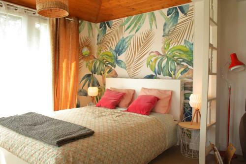 a bedroom with a bed with red pillows and a tropical wallpaper at Apartmán Marmeláda in Čtyřkoly