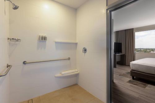 ein Bad mit Dusche und ein Bett in einem Zimmer in der Unterkunft Residence Inn by Marriott Cancun Hotel Zone in Cancún