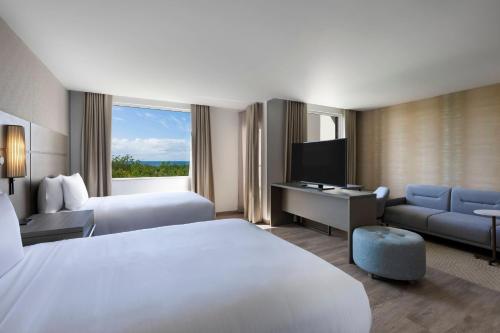 a hotel room with a bed and a desk and a television at Residence Inn by Marriott Cancun Hotel Zone in Cancún