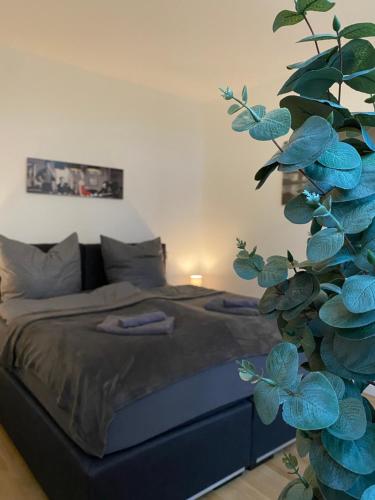 ein Schlafzimmer mit einem Bett und einer grünen Pflanze in der Unterkunft Residenz am Kurpark - Ferienwohnungen in zentraler Lage I Privatparkplatz in Bad Rothenfelde